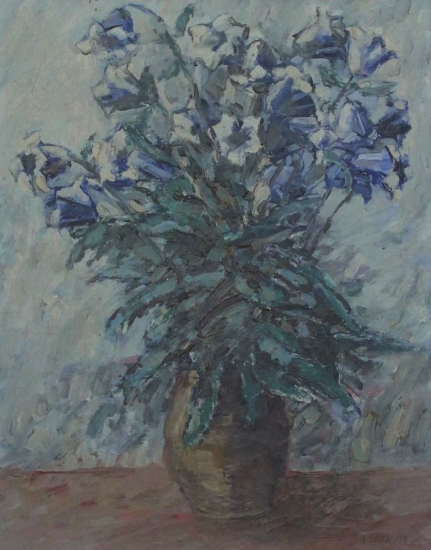 Buchet de flori albastre și albe, cu frunze lungi verzi-albăstrui, într-un ulcior de lut, pe fond cenușiu.
